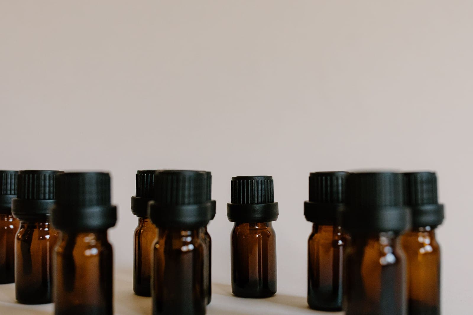 Amber glass fragrance oil bottles on a bench