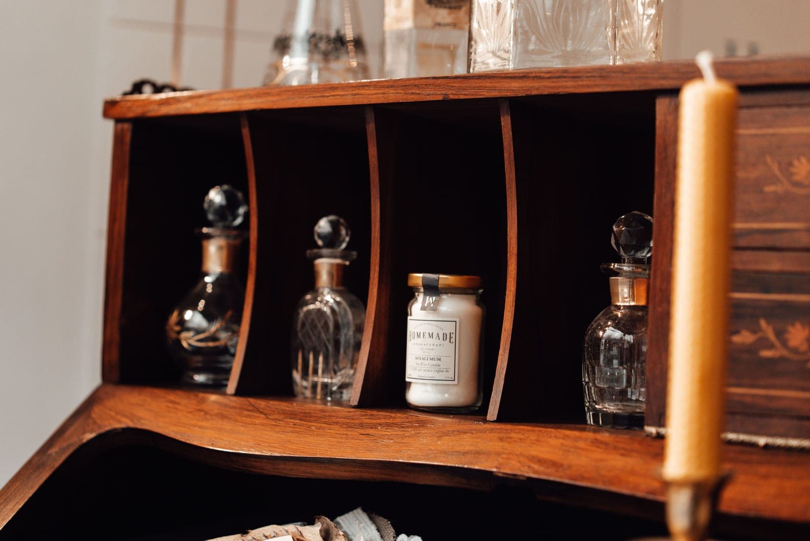Empty glass candle jars lined up on a shelf